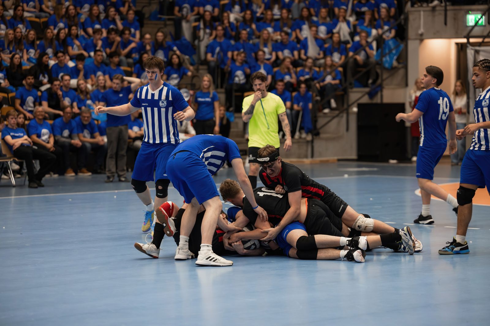 Spelare i en tacklingssituation på mattan under en match